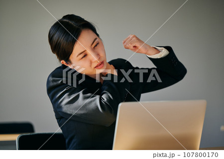 デスクワークで肩がこる若い女性 107800170