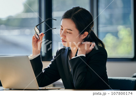 デスクワークで肩がこる若い女性 107800174