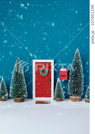 Miniature red Christmas door with Christmas trees still life. Creative Christmas composition. Christmas background. Miniature red Christmas door with Christmas trees still life. Creative Christmas composition. Christmas background. 107801290