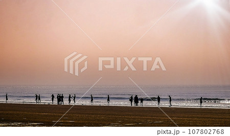 People enjoying the beauty of sea and beach by the sea shore in different ways of their own. Puri, India, Asia, February 2020. 107802768