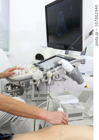 Ultrasonic examination of internal organs. A man on an abdominal ultrasound scan. Apparatus for ultrasonic examination. Modern ultrasound machine. 107802940
