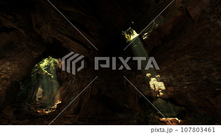 A cave illuminated by a mesmerizing volume of light shining through rocks 107803461