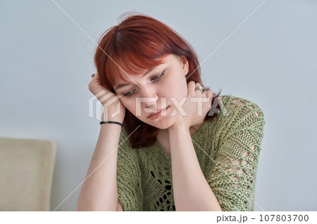 Sad upset teenage female, red-haired girl 19, 20 years old face close-up Sad upset teenage female, red-haired girl 19, 20 years old face close-up 107803700