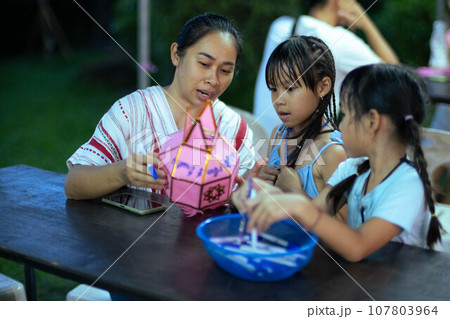 Asian families make wishes and hang lanterns during The Hundred Thousand Lantern Festival or Yi Peng Festival in northern Thailand. Asian families make wishes and hang lanterns during The Hundred Thousand Lantern Festival or Yi Peng Festival in northern Thailand. 107803964