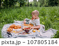 Boy child preschooler on a picnic. Smiles, eating cherries and enjoying summer. 107805184