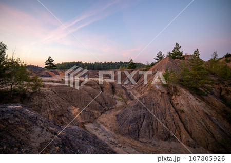 eroded soil quarry ravine with forest on its edge at summer evening eroded soil quarry ravine with forest on its edge at summer evening 107805926