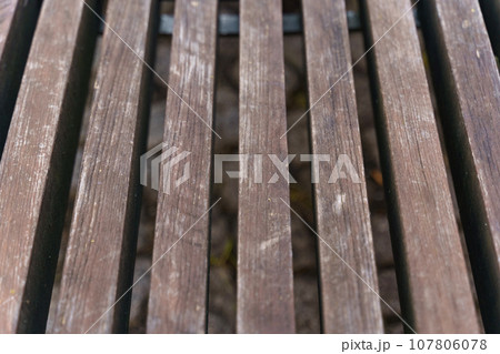 Brown wooden bench made of smooth beams. 107806078