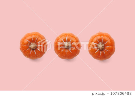 Three orange pumpkins on pastel color background 107806488