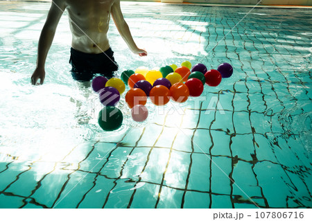 プールでボール拾いをして遊ぶ7歳 107806716