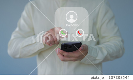Man answering the incoming call. The phone call was from an unknown number. Hoax person with a fake identity. Call center gang or stranger. Concept of scam, fraud with smartphone from the criminal. Man answering the incoming call. The phone call was from an unknown number. Hoax person with a fake identity. Call center gang or stranger. Concept of scam, fraud with smartphone from the criminal. 107808544