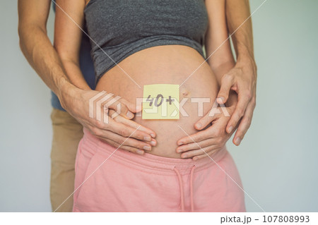 Radiant and confident, a woman in her 40s embraces pregnancy, defying age stereotypes and celebrating the beauty of motherhood 107808993