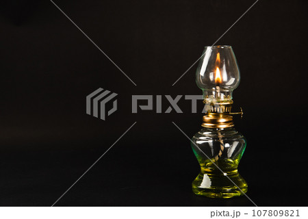 A captivating Diwali concept, An antique oil lamp at night against a black background, radiating a warm, glowing light. Perfect for festive greetings. A captivating Diwali concept, An antique oil lamp at night against a black background, radiating a warm, glowing light. Perfect for festive greetings. 107809821