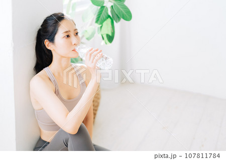 フィットネス中に水を飲む女性 107811784