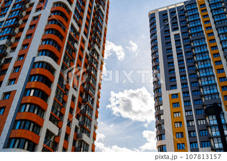 freshly built high rise apartment buildings on blue sky background with white clouds freshly built high rise apartment buildings on blue sky background with white clouds 107813157