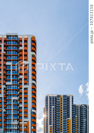 freshly built high rise apartment buildings on blue sky background with white clouds freshly built high rise apartment buildings on blue sky background with white clouds 107813158