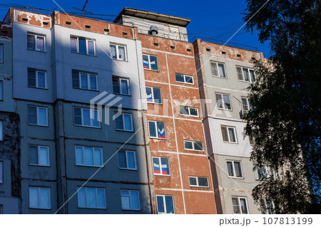 typical russian ugly high rise apartmant building with russian national flags in some windows at summer day typical russian ugly high rise apartmant building with russian national flags in some windows at summer day 107813199