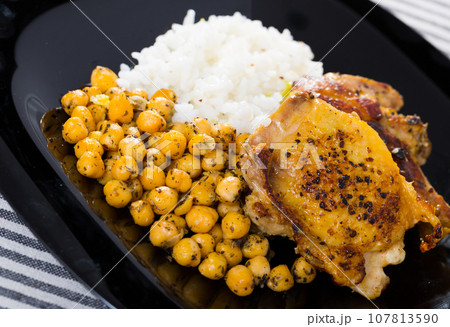 Roasted chicken thighs with chickpeas, rice on black dish Roasted chicken thighs with chickpeas, rice on black dish 107813590
