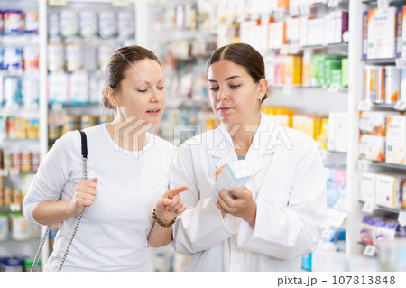 In cosmetic department of pharmacy, buyer asks consultant to help and choose cleansing gel. In cosmetic department of pharmacy, buyer asks consultant to help and choose cleansing gel. 107813848