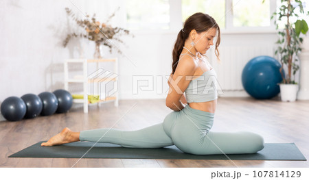 Woman wearing sportwear doing Yoga exercise,Yoga One Legged King Pigeon pose or Eka Pada Rajakapotasana, calm of healthy woman breathing and meditation with yoga 107814129