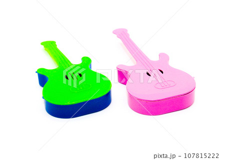 Toy guitar on white background with selective focus Toy guitar on white background with selective focus 107815222