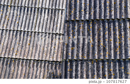 Two grey shabby slate roofs of old retro houses together. Background Two grey shabby slate roofs of old retro houses together. Background 107817627