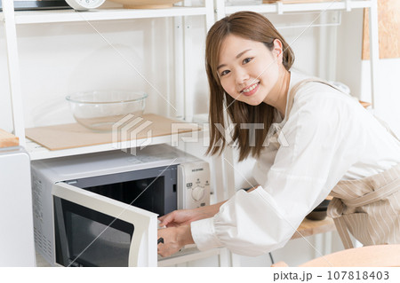 電子レンジを使う若い女性 電子レンジを使う若い女性 107818403