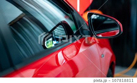 Side rear view window on the new red modern car. Side rear view window on the new red modern car. 107818811