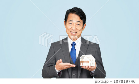 住宅模型を見せる中年ビジネスマン 107819746
