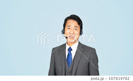 ヘッドセットをつけて話す中年ビジネスマン ヘッドセットをつけて話す中年ビジネスマン 107819782