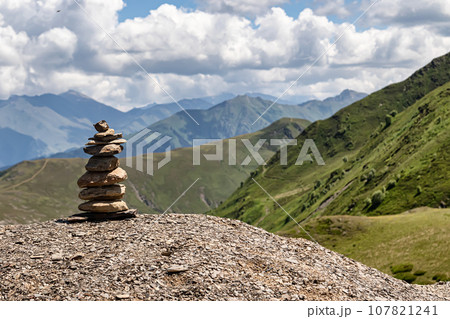Small pebbles are made up in a tower and keep the balance, personify balance and tranquility Small pebbles are made up in a tower and keep the balance, personify balance and tranquility 107821241