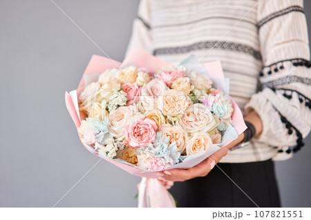 Small Beautiful bouquets of mixed flowers in woman hand. Floral shop concept . Beautiful fresh cut bouquet. Flowers delivery Small Beautiful bouquets of mixed flowers in woman hand. Floral shop concept . Beautiful fresh cut bouquet. Flowers delivery 107821551
