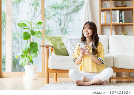 リビングでスマホを見る若い女性 リビングでスマホを見る若い女性 107821629