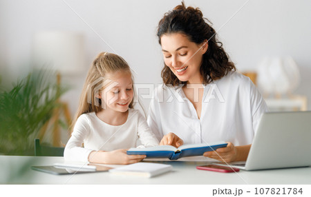Girl doing homework or online education. Girl doing homework or online education. 107821784