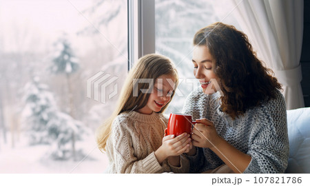 Mother and daughter enjoying winter nature in the window Mother and daughter enjoying winter nature in the window 107821786