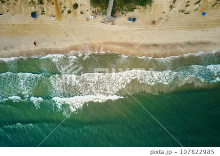 Sand beach with sea waves, top view. Summer vacation and travel concept. Beautiful coastline with blue sea in Wladyslawowo, Poland Sand beach with sea waves, top view. Summer vacation and travel concept. Beautiful coastline with blue sea in Wladyslawowo, Poland 107822985