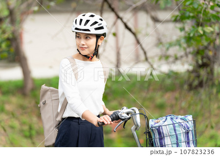 サイクリングヘルメットをかぶって後方確認する若い女性 107823236