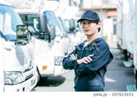 トラックの前に立つ若い男性 107823653