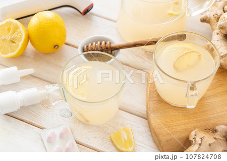Natural cold remedies concept - ginger tea and ingredients, drugs, thermometer 107824708