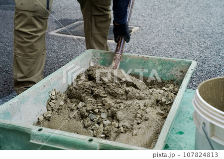 モルタルに砕石を混ぜてコンクリートを練る職人　左官工事03 107824813