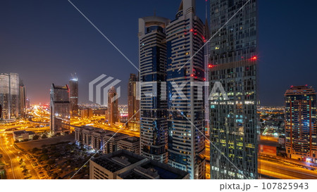 Aerial view of Dubai International Financial District with many skyscrapers all night timelapse. 107825943