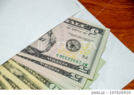 Dollars on table with an envelope. Money in an envelope. U.S. dollars. Dollars on table with an envelope. Money in an envelope. U.S. dollars. 107826910