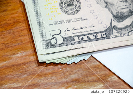 Dollars on a wooden table. Money on table. American dollars. Dollars on a wooden table. Money on table. American dollars. 107826929