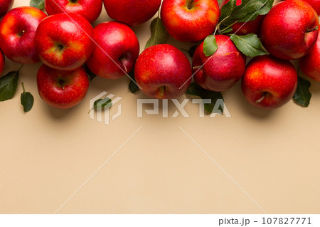 Many red apples on colored background, top view. Autumn pattern with fresh apple above view with copy space for design or text 107827771