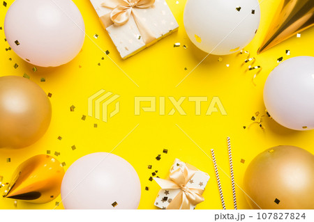 Holiday background with colorful balloon, gift and confetti. Flat lay style. Birthday or party greeting card with copy space 107827824