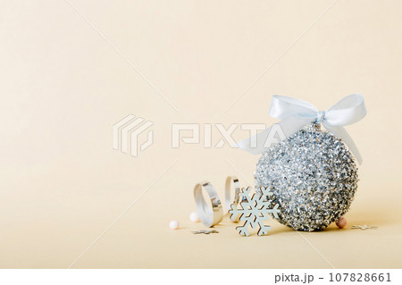Christmas ball on colored background. decoration bauble with ribbon bow with copy space 107828661