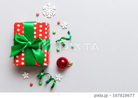 Top view Flat lay Christmas decorations and gift box on colored background with copy space. Christmas or Happy New Year composition Top view Flat lay Christmas decorations and gift box on colored background with copy space. Christmas or Happy New Year composition 107828677