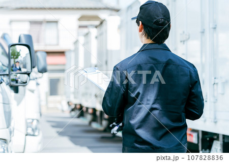 トラックの前に立つ若い男性 107828836