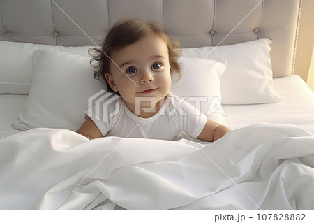 Overhead view of baby sitting on bed. The concept of childhood. 107828882