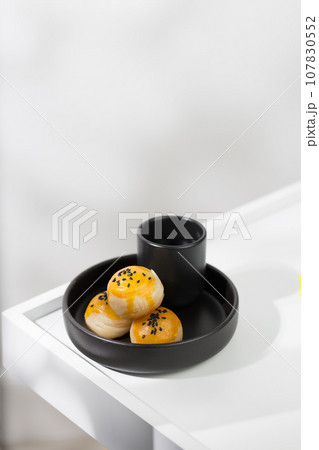 Chinese pastry and hot tea in a black ceramic cup. Chinese pastry and hot tea in a black ceramic cup. 107830552