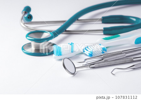 Dental care and treatment concept, dentist tools and toothbrush on white background Dental care and treatment concept, dentist tools and toothbrush on white background 107831112